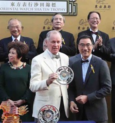 Mr. Michael TH Lee, Steward of the Hong Kong Jockey Club, presents the Trophy and silver dish to trainer John Moore and jockey Derek Leung