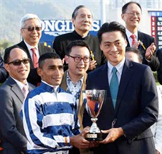 Mr. Oscar Chow Vee Tsung, Non-Executive Director of Chevalier International Holdings Limited, presents a replica trophy to winning jockey Karis Teetan